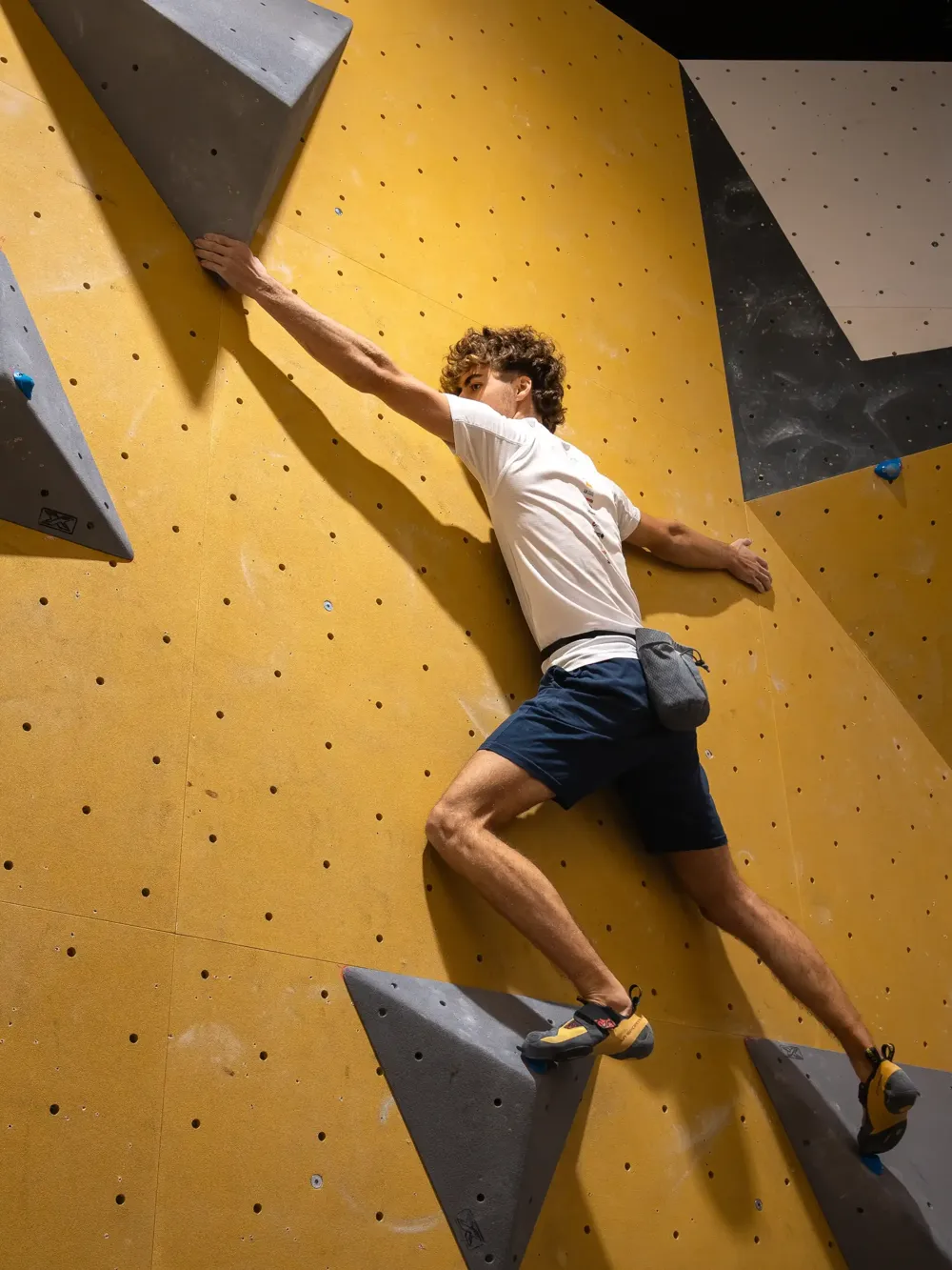 Escalador lanzándose a una presa en el Urban Boulder Txapelketa
